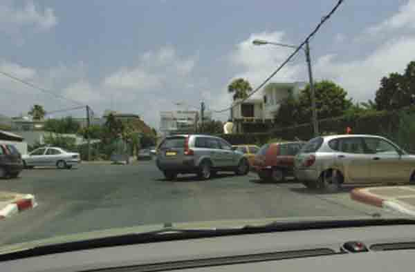 תמרור : בתמונה שלפניך מופיע רכב כסוף היוצא מחנייה בנסיעה לאחור. כיצד תגיב?