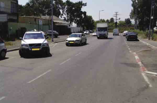 תמרור : בתמונה שלפניך, תגובת הנוהגים בדרך לרכב היוצא מהחניה אינה ברורה. כיצד צריך להגיב נהג המשאית במצב זה?
